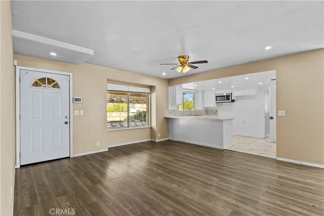 a view of a hallway with wooden floor and a living room