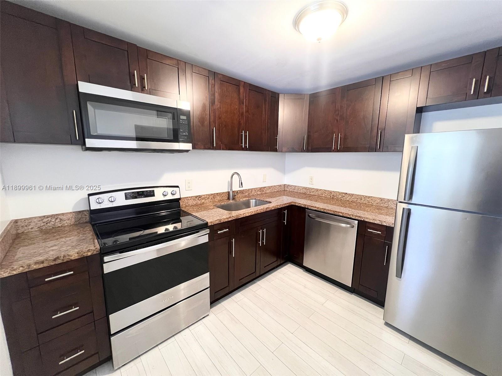 a kitchen with a refrigerator sink and wooden cabinets
