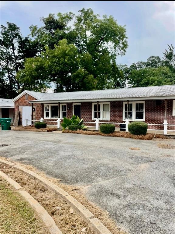 103 East Main Street Irwinton, GA 31042 - Photo 3 of 4 a front view of a house with a yard and potted plants