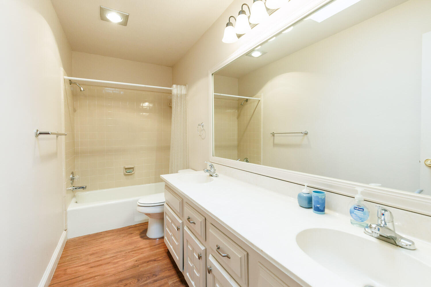 5728 92nd Street Lubbock, TX 79424 - Photo 27 of 40 a bathroom with a double vanity sink toilet mirror and bathtub