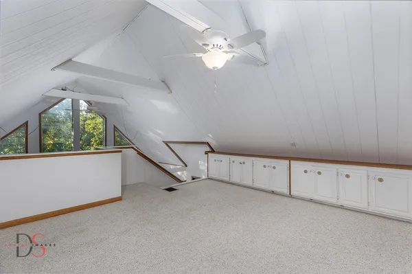 an empty room with chandelier fan