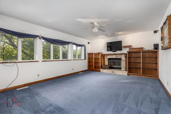 wooden floor in an empty room with a window and a kitchen