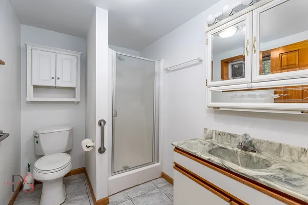 a bathroom with a granite countertop toilet sink and mirror