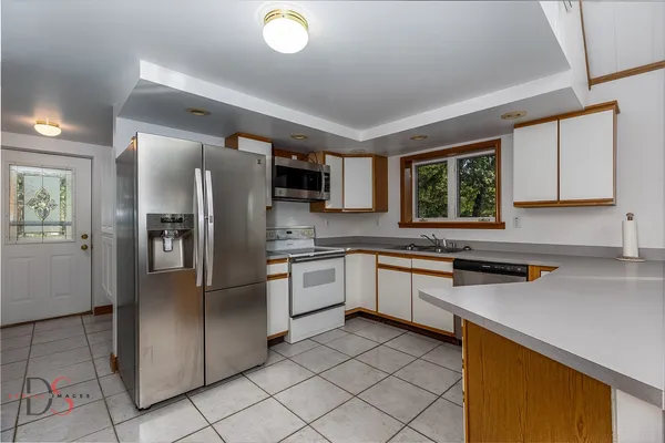 a kitchen with stainless steel appliances granite countertop a refrigerator sink and stove