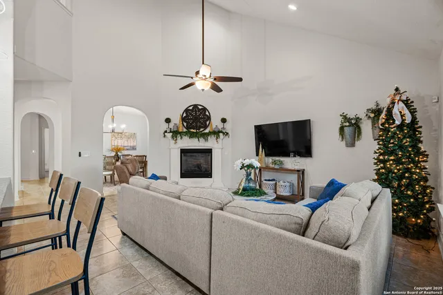 a living room with furniture a flat screen tv and a fireplace