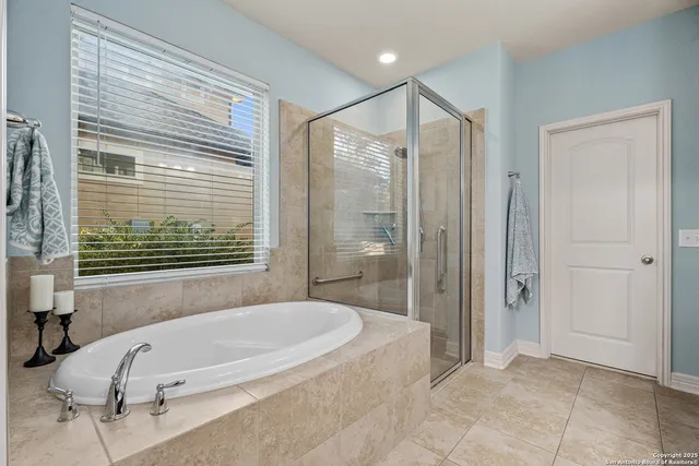 a bathroom with a tub shower and window