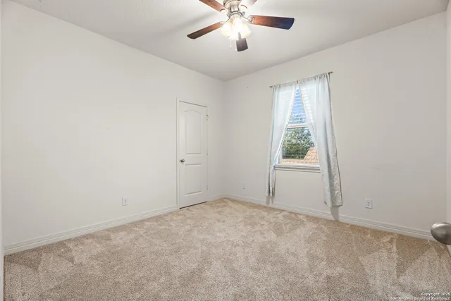 an empty room with a window and a fan
