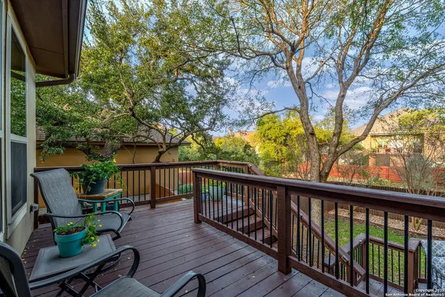a view of a balcony with chairs and wooden fence