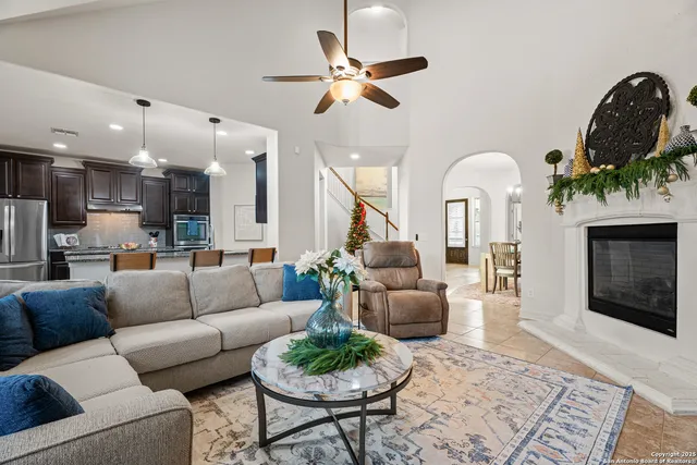 a living room with furniture a fireplace and a chandelier