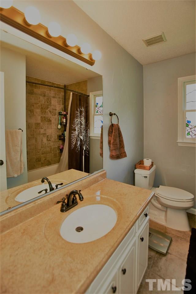 517 Jordan Ridge Lane Raleigh, NC 27603 - Photo 13 of 16 a bathroom with a granite countertop sink and a mirror