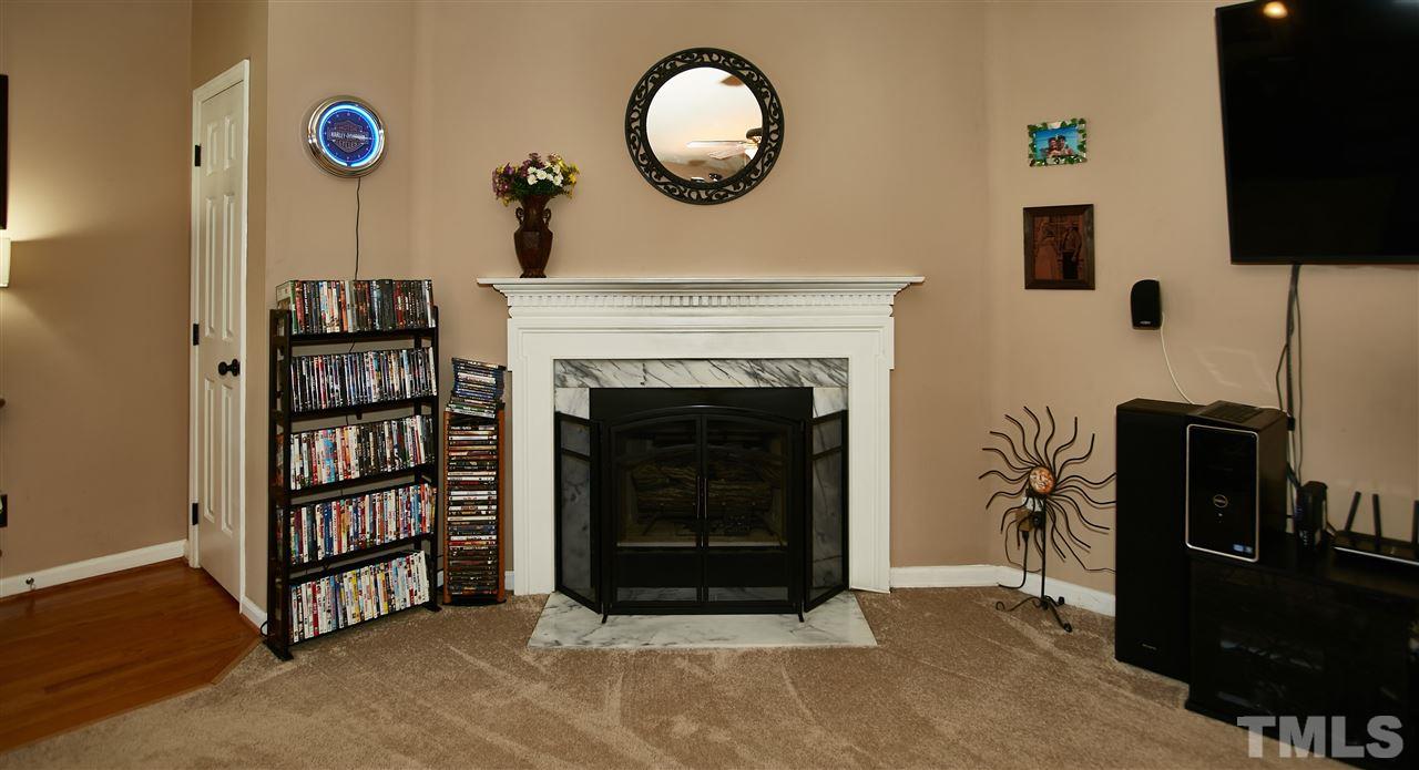 517 Jordan Ridge Lane Raleigh, NC 27603 - Photo 4 of 16 a living room with furniture a flat screen tv and a fireplace