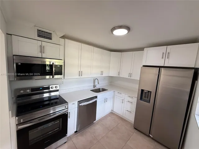 a kitchen with stainless steel appliances a refrigerator stove and microwave