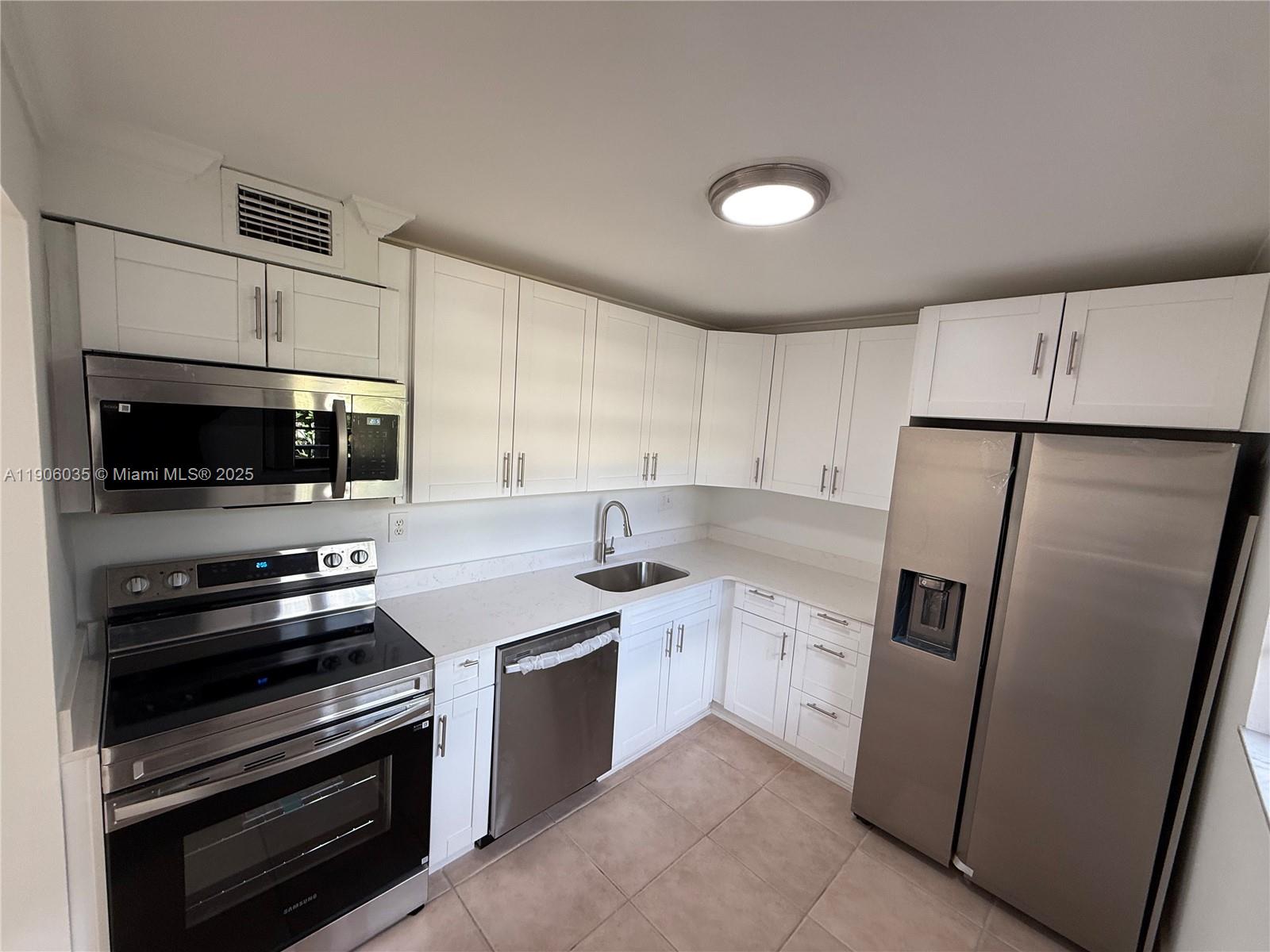 a kitchen with stainless steel appliances a refrigerator stove and microwave