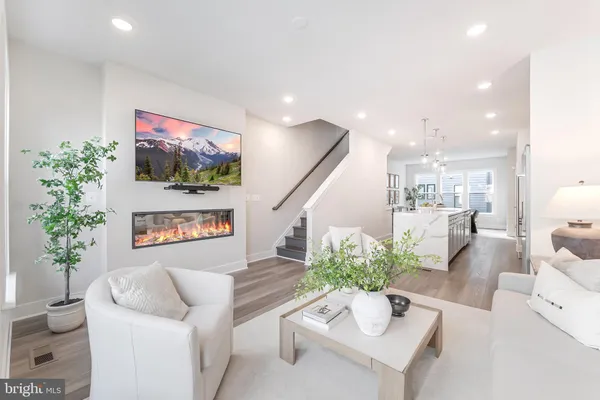 a living room with furniture a flat screen tv and a floor to ceiling window