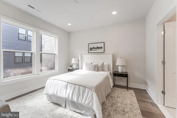a bedroom with a bed and a large mirror on the dresser