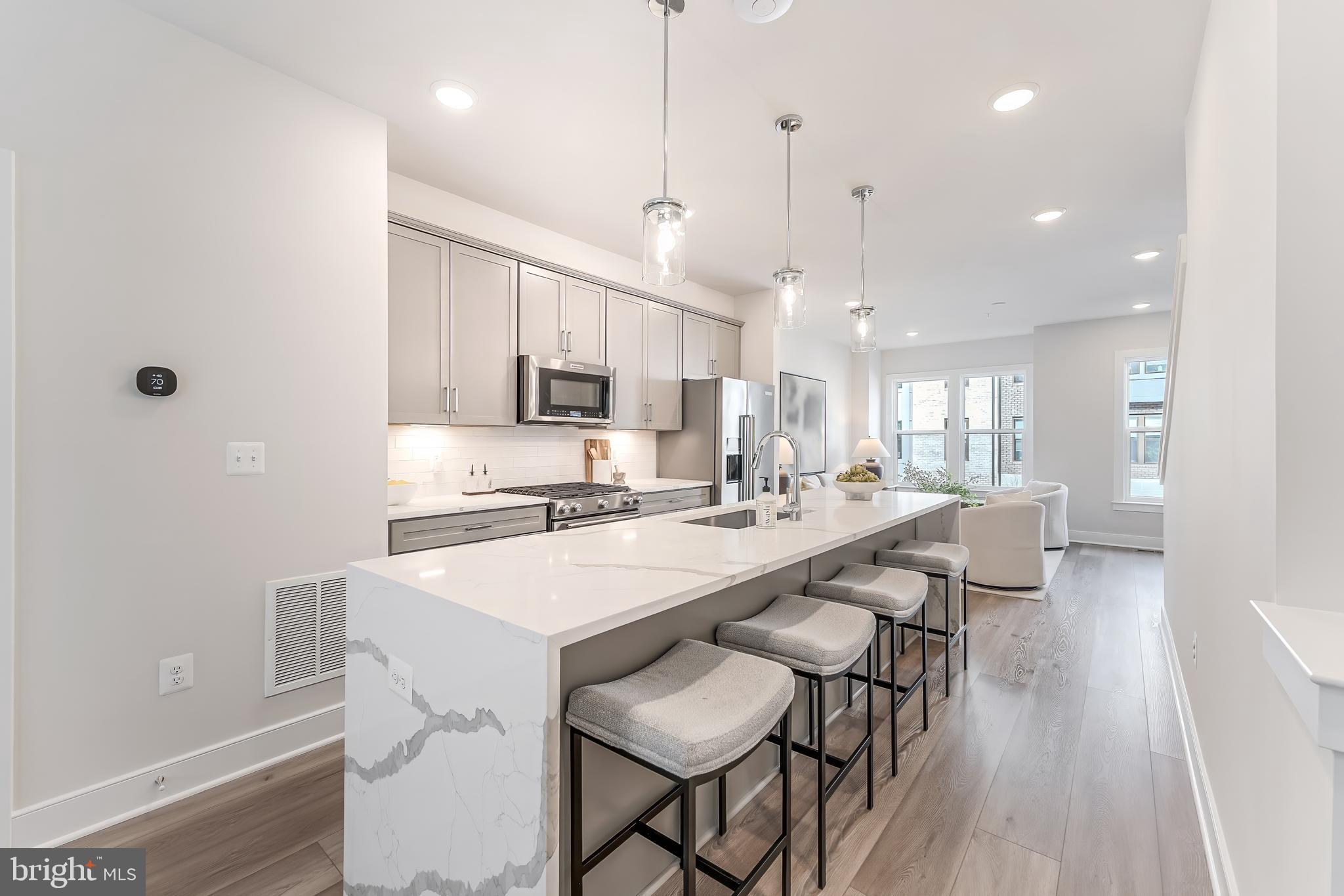 12742 Verdant Way Reston, VA 20191 - Photo 8 of 51 a large kitchen with kitchen island a dining table and chairs