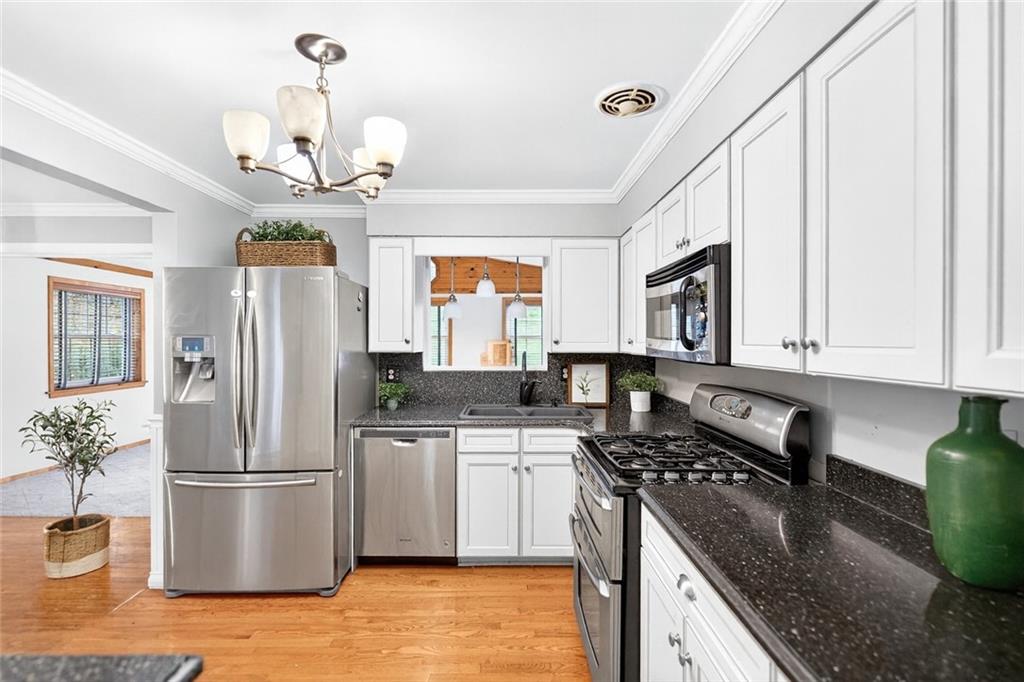 910 Burchfield Road Allison Park, PA 15101 - Photo 9 of 21 a kitchen with stainless steel appliances granite countertop a refrigerator a stove a sink dishwasher and white cabinets with wooden floor