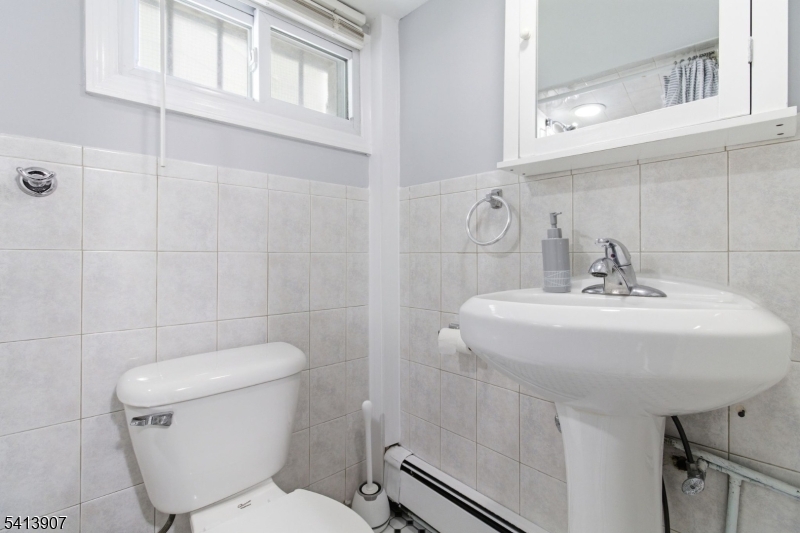 32 Cedar Avenue Elizabeth, NJ 07202 - Photo 27 of 32 a bathroom with a toilet sink and a mirror