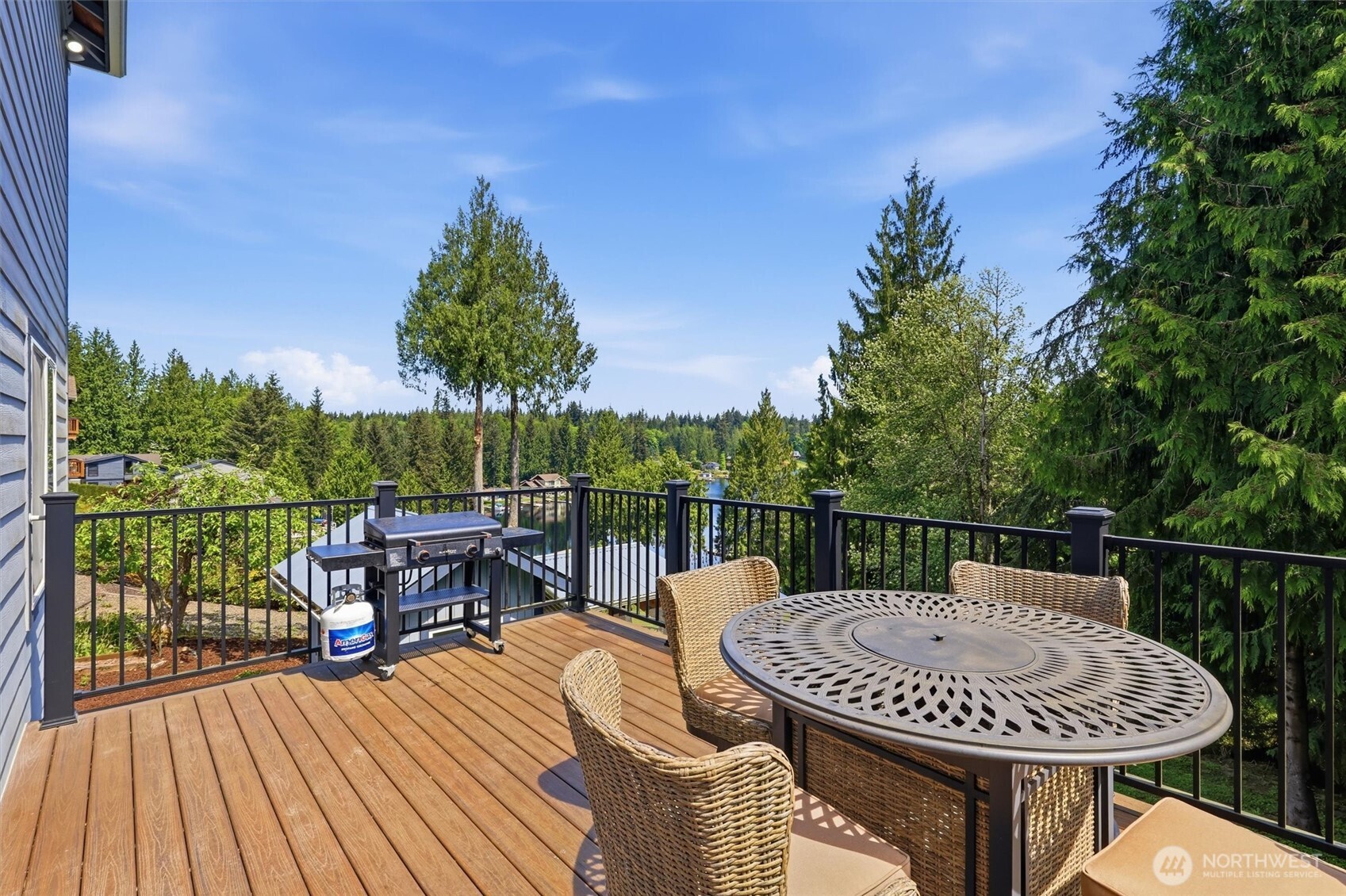5523 East Wishon Road Snohomish, WA 98290 - Photo 32 of 39 a view of a roof deck with table and chairs couches with wooden floor and fence