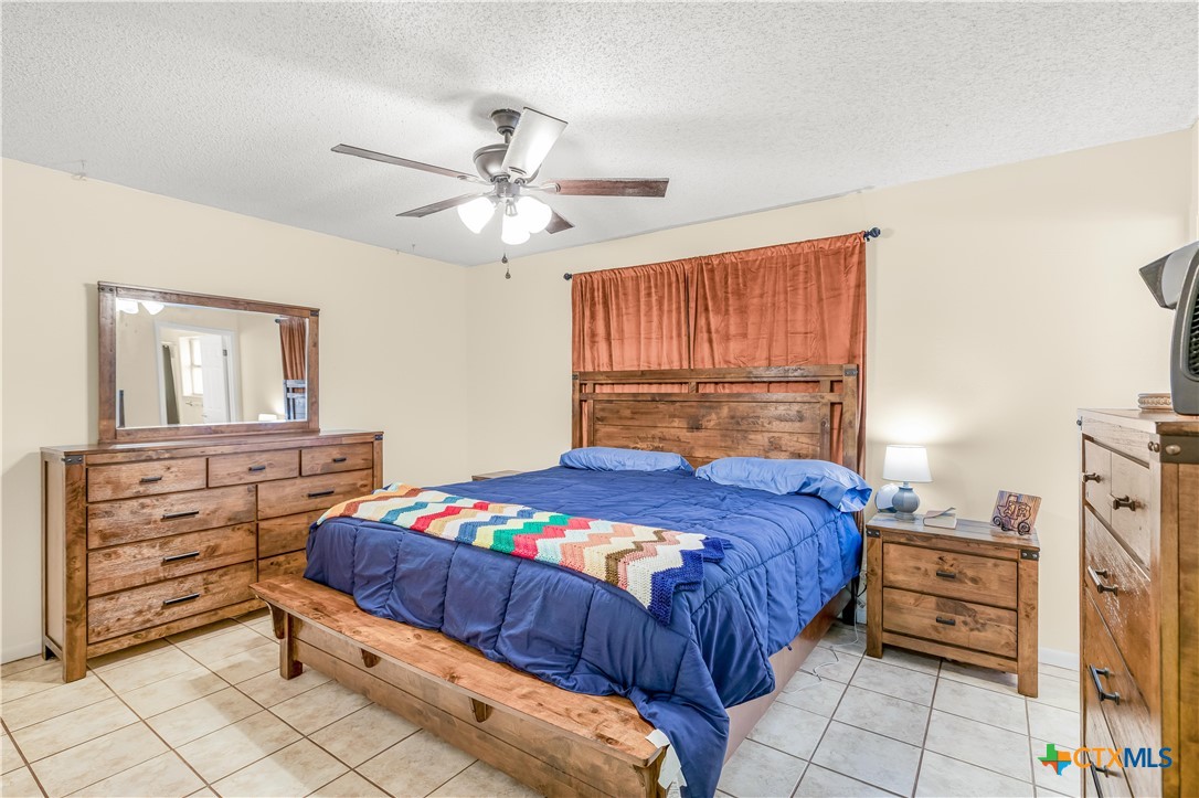 307 Pheasant Drive Victoria, TX 77905 - Photo 11 of 33 a bedroom with a bed and a chandelier