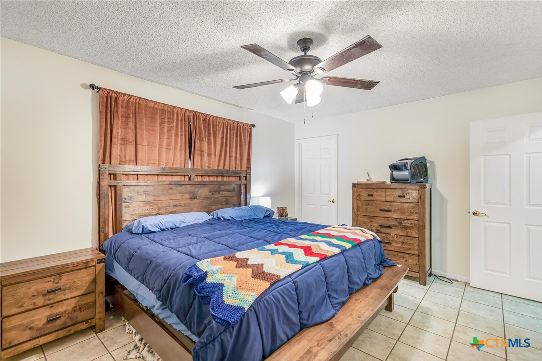 307 Pheasant Drive Victoria, TX 77905 - Photo 12 of 33 a bedroom with a bed a dresser and a chandelier