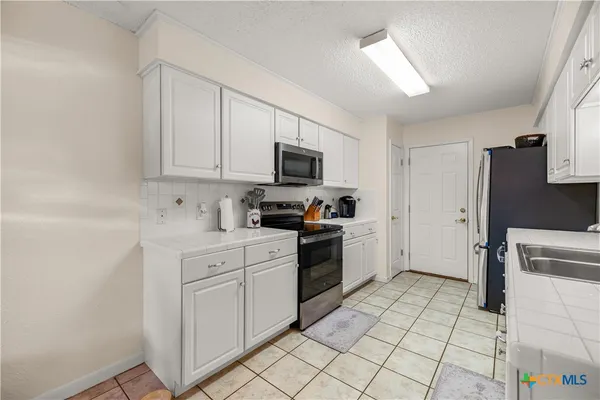 a kitchen with a sink cabinets and appliances