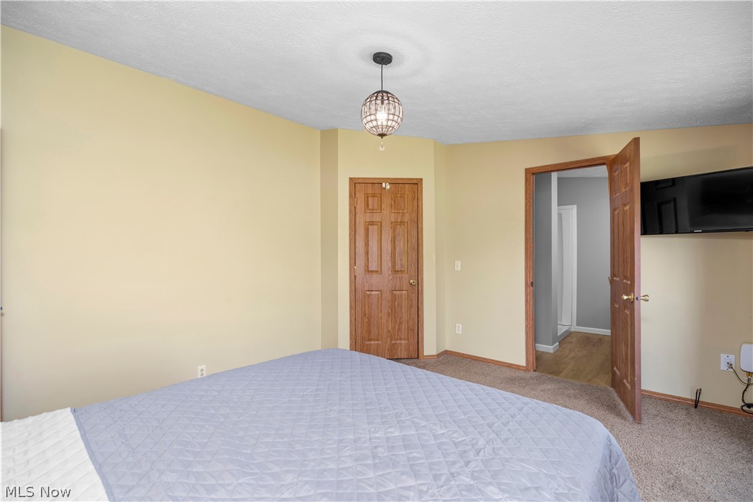 294 Twp 150 Road Sullivan, OH 44880 - Photo 28 of 39 Bedroom featuring a textured ceiling, neutral wall paint, and a decorative ceiling fixture