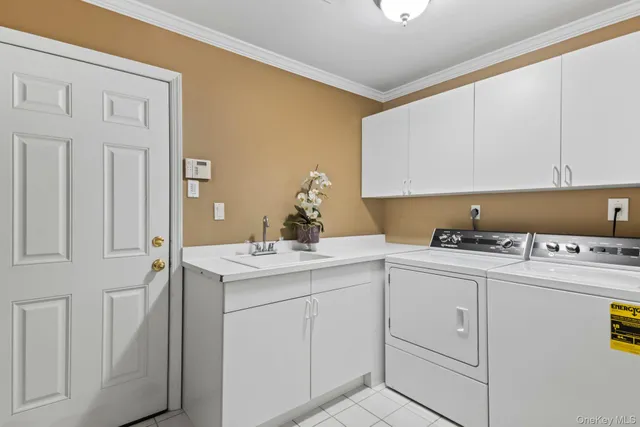 a utility room with cabinets washer and dryer