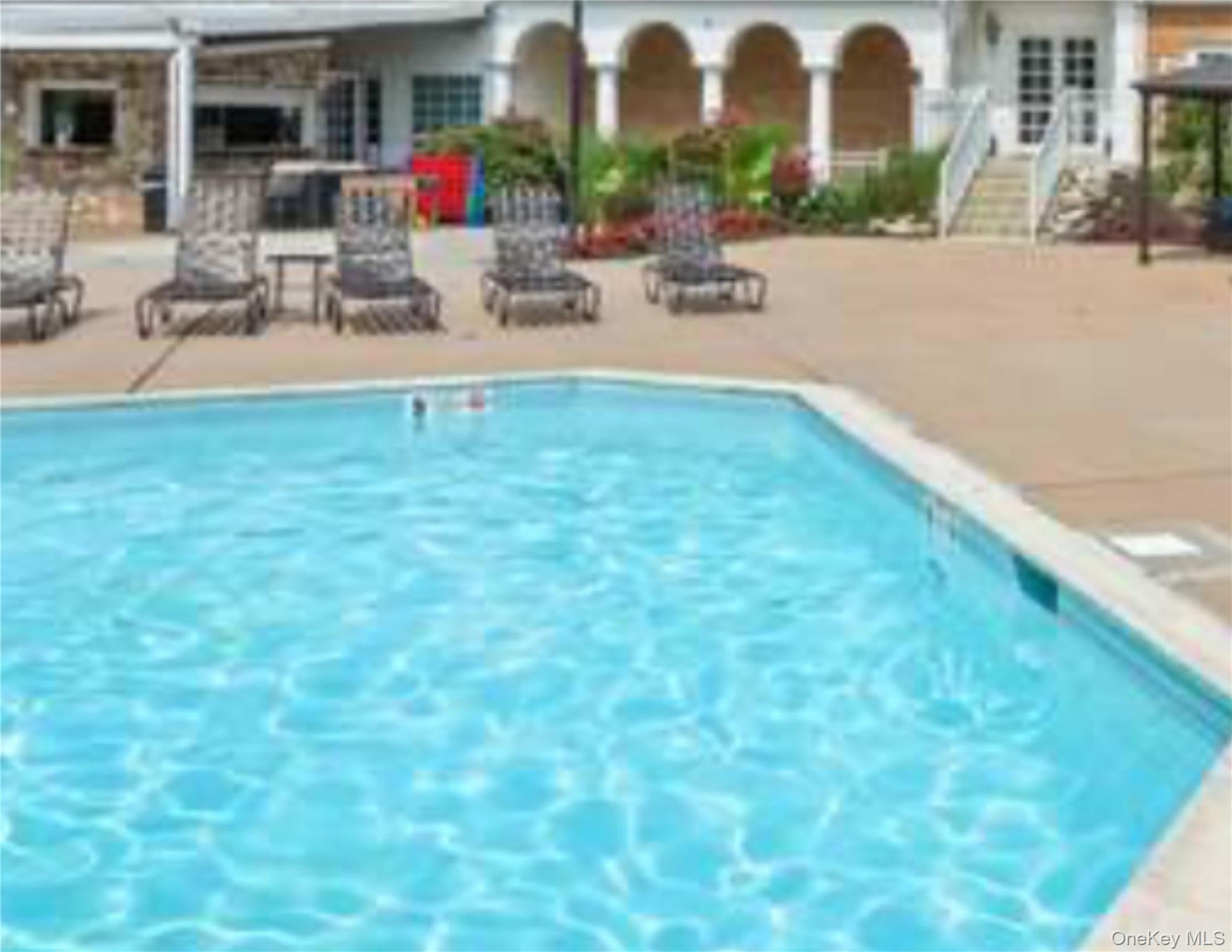 77 The Woods Commack, NY 11725 - Photo 29 of 31 Community pool with a patio area