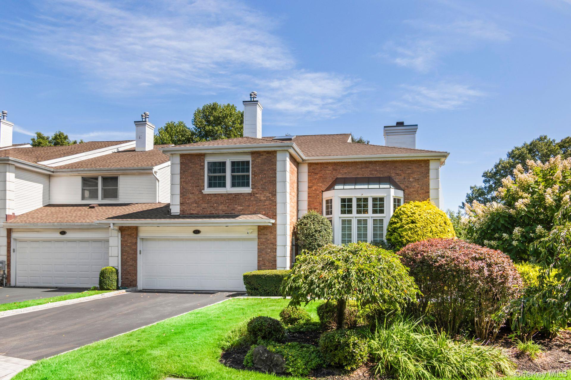 77 The Woods Commack, NY 11725 - Photo 3 of 31 View of front of home with a chimney, asphalt driveway, brick siding, and a garage