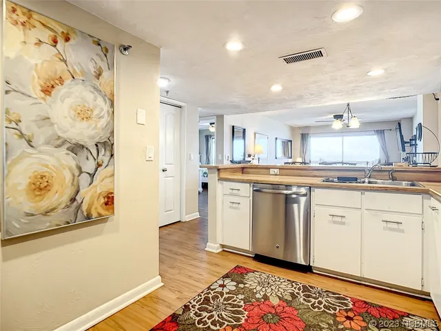 a kitchen with stainless steel appliances granite countertop a stove a sink and white cabinets