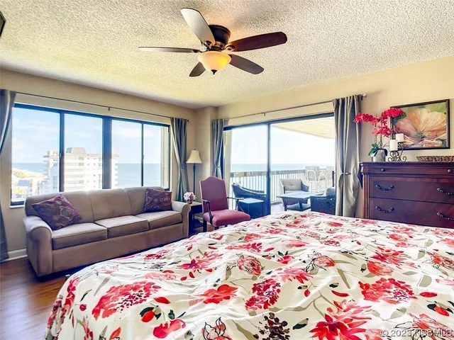 a bedroom with a bed and a flat tv screen on dresser
