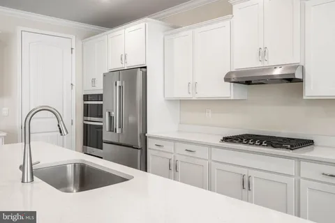 a kitchen with a sink stove and white cabinets