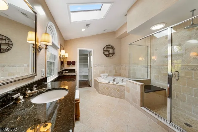 a bathroom with a granite countertop sink mirror and bathtub