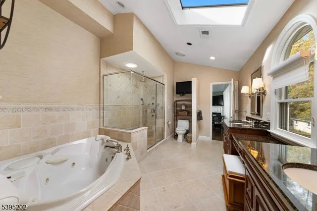 a large spacious bathroom with a tub shower and mirror