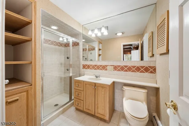 a spacious bathroom with a granite countertop sink toilet a mirror and shower