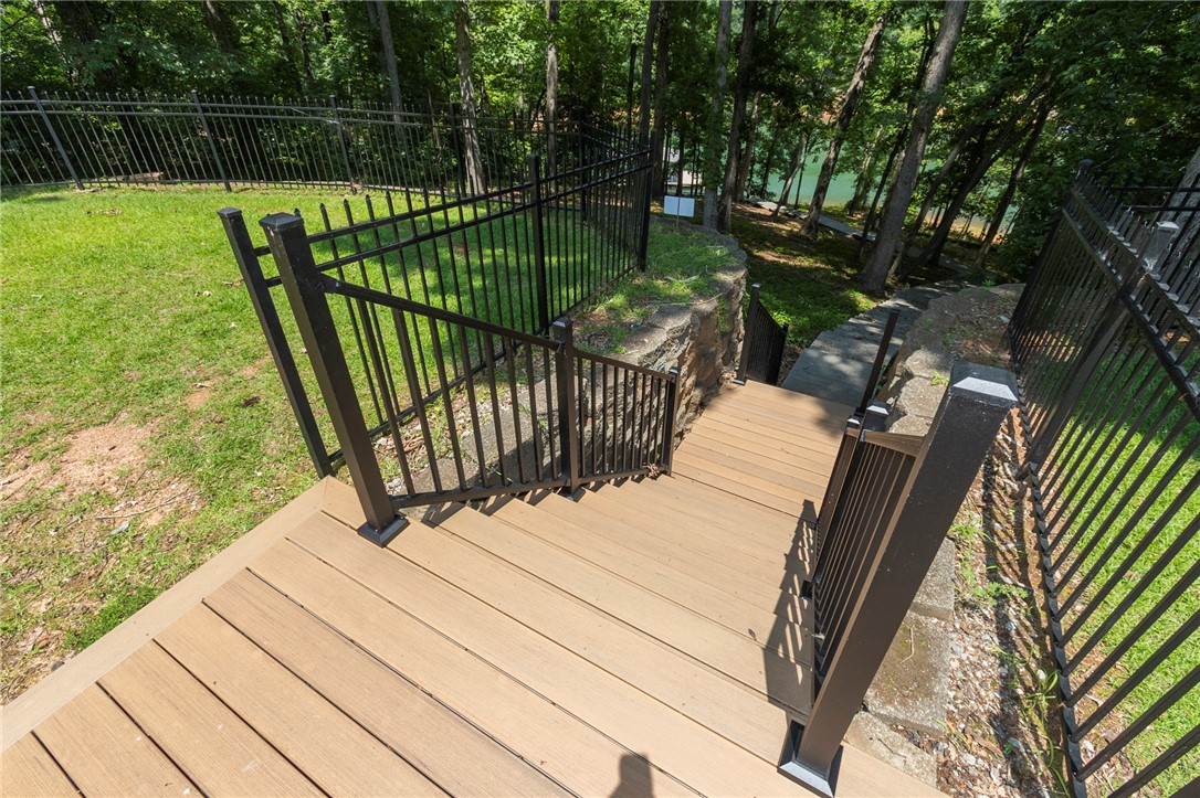 202 Plantation Point Anderson, SC 29625 - Photo 42 of 48 Access to the waterfront from this verdant yard, featuring a durable wooden deck and secure fencing.