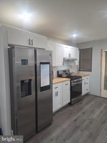 a kitchen with a refrigerator sink and cabinets