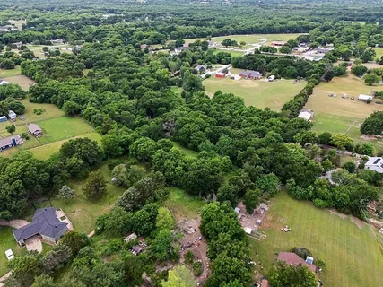 an aerial view of residential houses with outdoor space and lake view