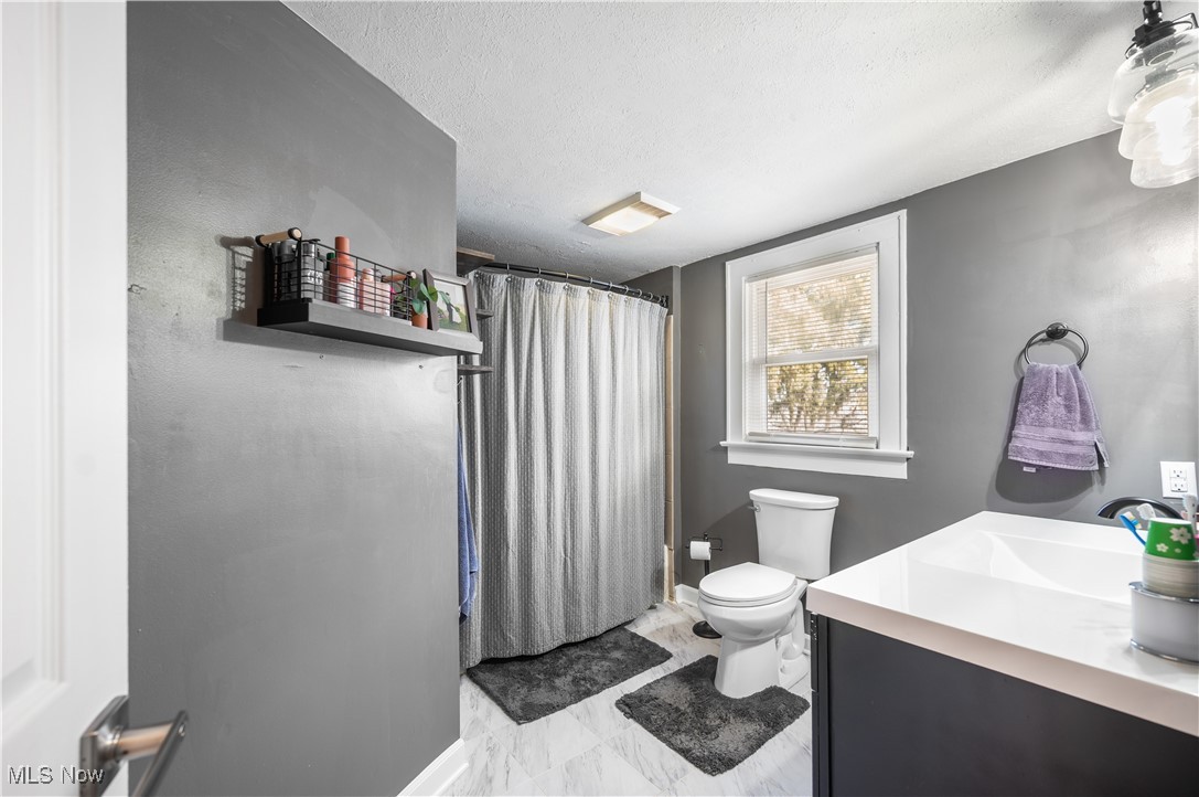 1615 Wooster Road West Barberton, OH 44203 - Photo 14 of 28 Bathroom with a textured ceiling, a shower with shower curtain, vanity, and toilet