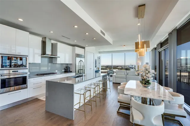 a view of a dining room with furniture a kitchen and chandelier