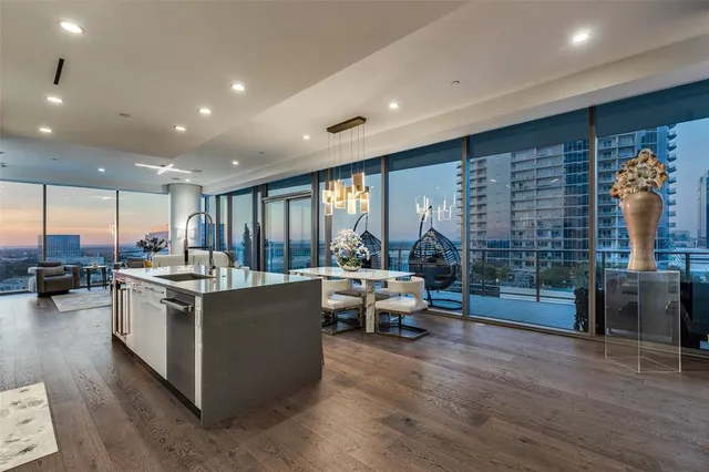 a kitchen with stainless steel appliances kitchen island granite countertop a stove and a wooden floors