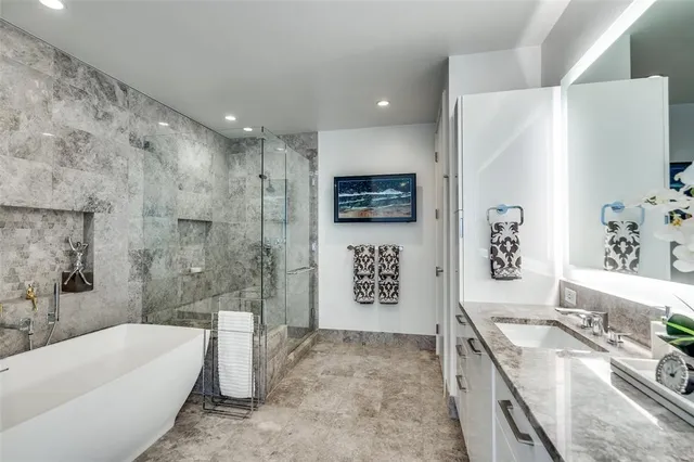 a bathroom with a granite countertop sink a bathtub and a shower
