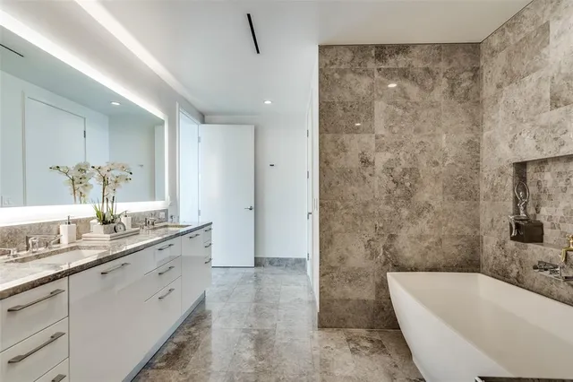 a bathroom with a granite countertop sink a bathtub a mirror and a shower