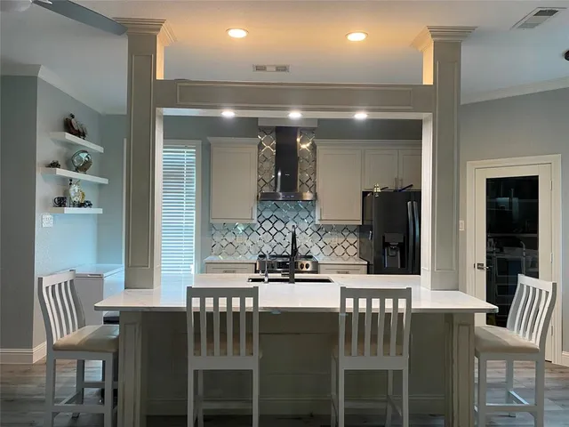 a kitchen with a dining table chairs and refrigerator