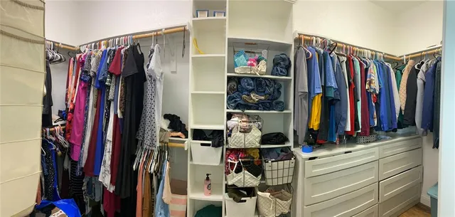 a view of walk in closet with clothes