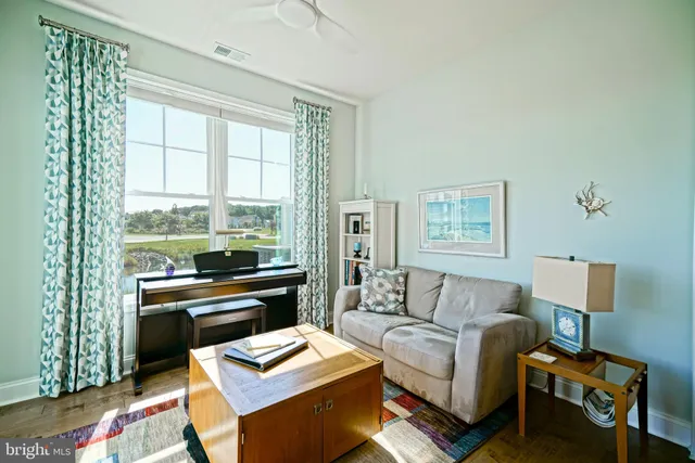 a living room with furniture and a floor to ceiling window
