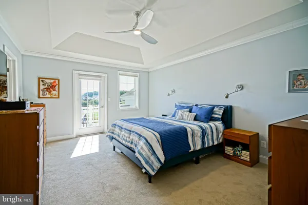 a bedroom with a bed and a flat tv screen on dresser