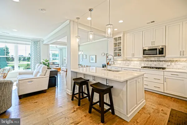 a large white kitchen with lots of counter space and painting on the wall
