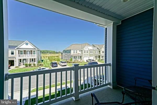 a patio with table and chairs and potted plants